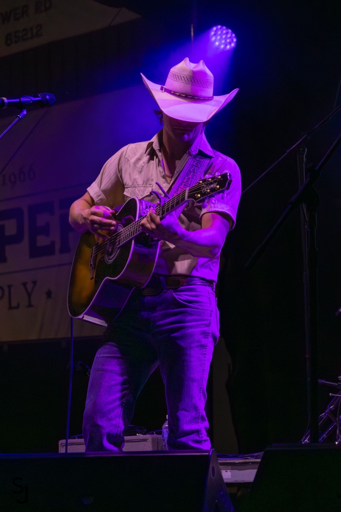 country music artist plays on the stage at night during the Horseshoe Harvest Hangout Concert.